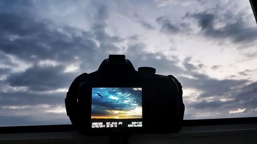 Low angle view of silhouette camera against sky