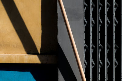 Close-up of metal railing against building on sunny day