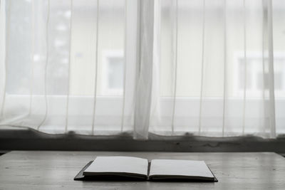 Close-up of open book on table at home