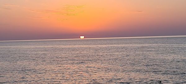 Scenic view of sea against orange sky