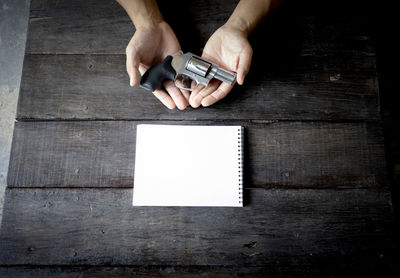 Low section of person holding paper on table