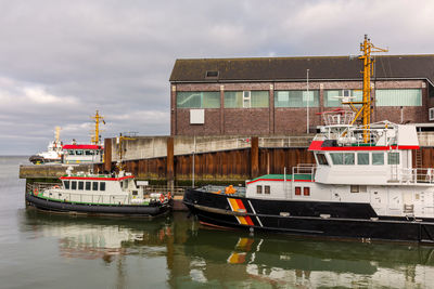 Boats moored on river against sky