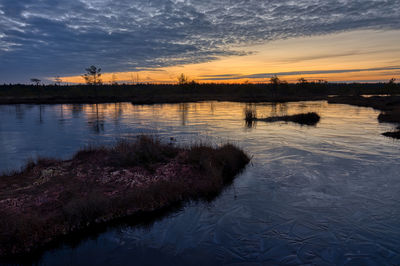 Scenic view of lake against sky at sunset