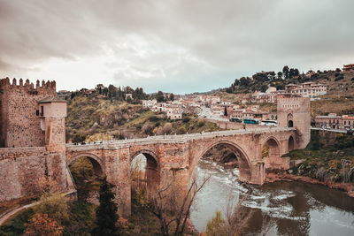 Old arched bridge crossing a river in toledo city.