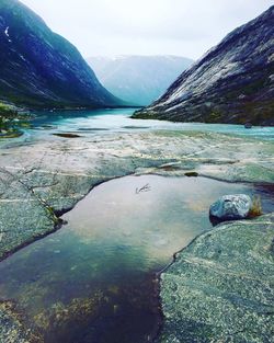 Scenic view of river amidst mountains against sky