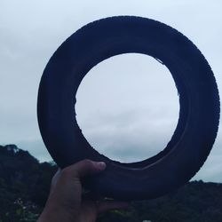 Person holding umbrella against sky