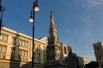 Low angle view of street light by obelisco dell immacolata against sky