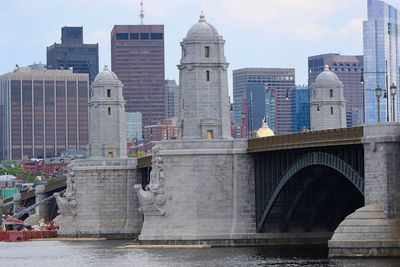 Bridge over river against buildings in city