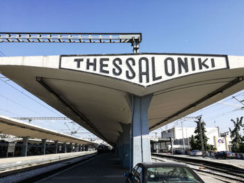 Information sign on railroad tracks against clear sky