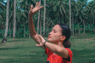 Side view of young woman exercising in park