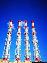 Low angle view of communications tower against clear blue sky