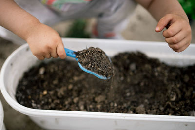 Little girl have fun with small spatula in the garden.