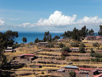 High angle view of houses by sea against sky