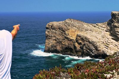 View of rocks against calm blue sea