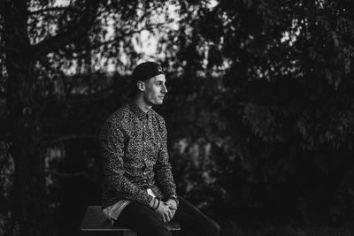 Young man looking away in forest