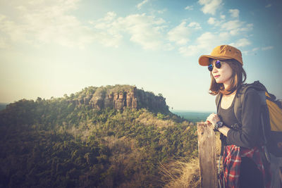 Woman looking at camera against sky