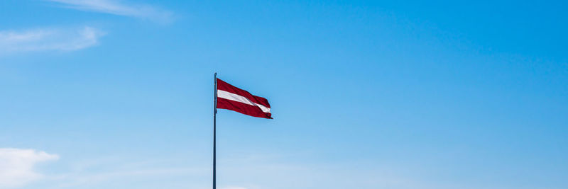 Low angle view of flag against blue sky