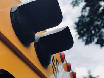 Low angle view of lighting equipment on school bus against sky