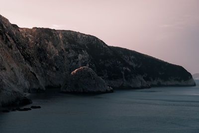 Scenic view of sea and mountains against sky