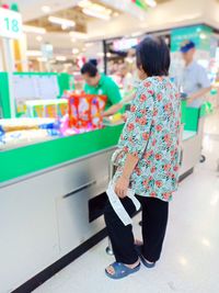 Rear view of friends standing at market