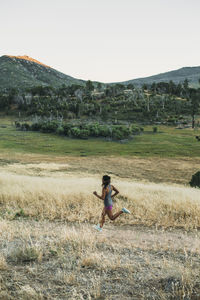 High angle view of athlete woman running on grassy field