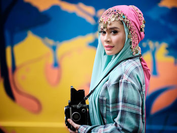 Beautiful asian female posing with a retro camera