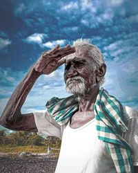 Portrait of man on rock against sky