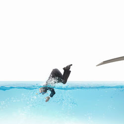 Man swimming in sea against clear sky