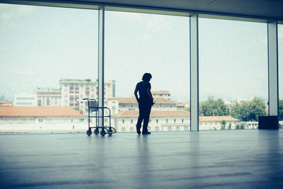 Rear view of man with umbrella on glass window