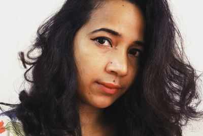 Close-up portrait of beautiful woman against white background