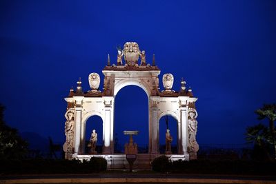 Low angle view of illuminated building against blue sky