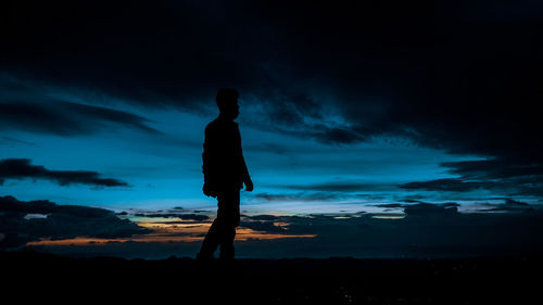 Silhouette man standing against sky during sunset