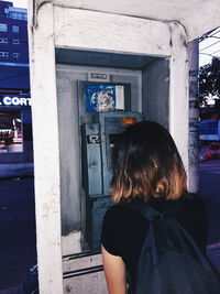 Rear view of woman standing in front of building