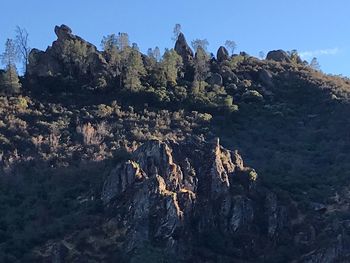 Low angle view of rock formations against clear blue sky