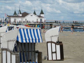 Chairs on beach against sky