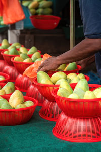 Fresh mangoes in red baskets at the stall.