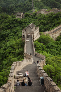 Tourists at great wall of china by trees against sky