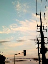 Low angle view of silhouette electricity pylon against sky