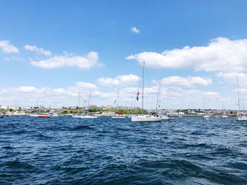 Sailboats sailing on sea against sky