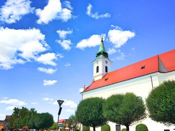 Low angle view of trees and building against sky