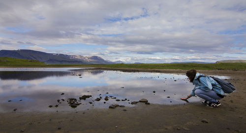 Rear view of man standing on lakeshore