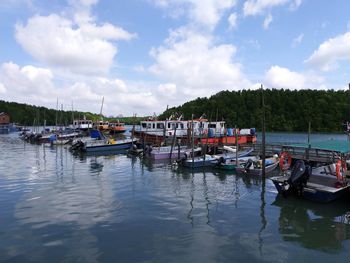 Boats moored in lake against sky