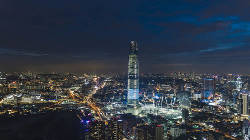 Illuminated buildings in city against sky at night