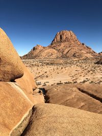 Scenic view of desert against clear blue sky