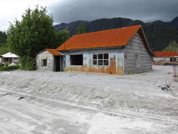 Houses on field by building against sky