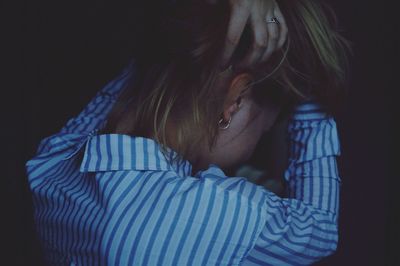 Woman standing with hand in hair at darkroom