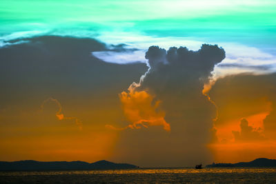 Scenic view of sea against dramatic sky during sunset