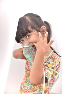 Portrait of boy holding camera over white background