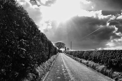 Country road against cloudy sky