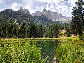 Scenic view of lake by mountains against sky